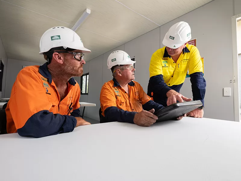 workers discussing plans with hard hats on