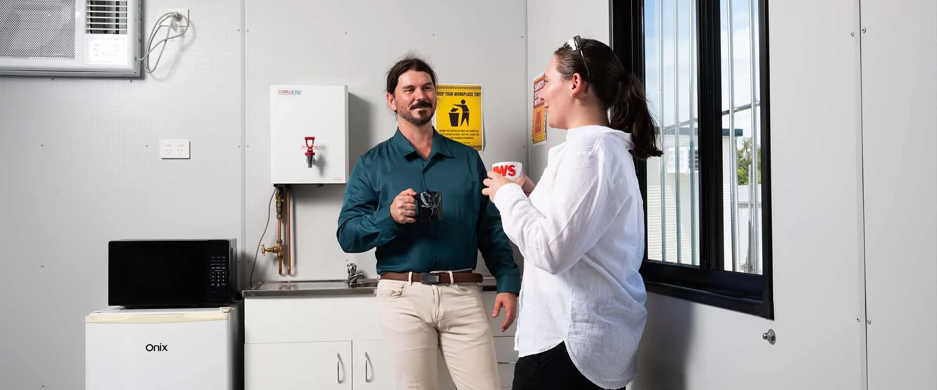 two people drinking coffee inside modular building
