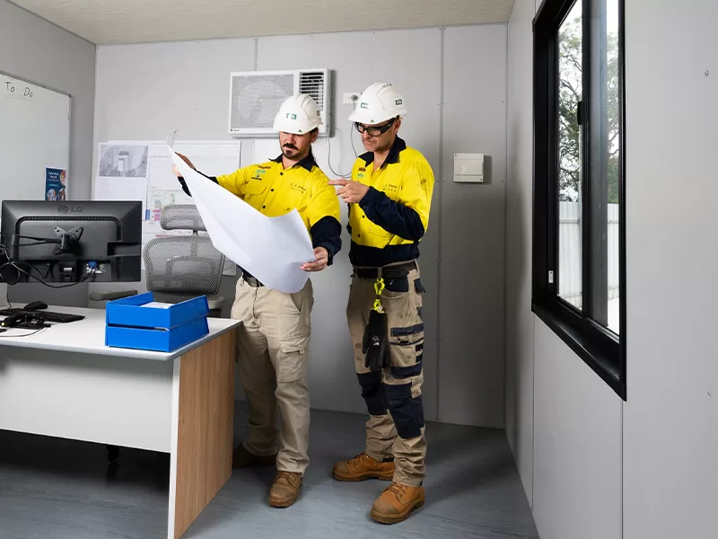 two workers looking at plans for building